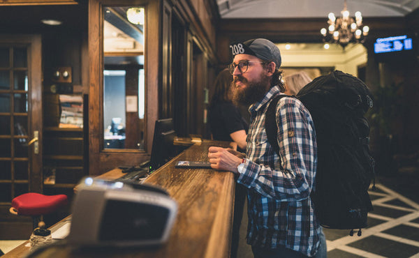 A person checking into a hotel wearing the Hero's Journey Pack